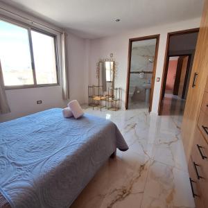 a bedroom with a blue bed and a bathroom at Depas Ocampo in Morelia