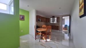 a kitchen with green walls and a table and chairs at Depas Ocampo in Morelia +38 photos