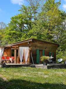 a small wooden cabin with a green door at chalet atypique, Ile chambod in Echallon