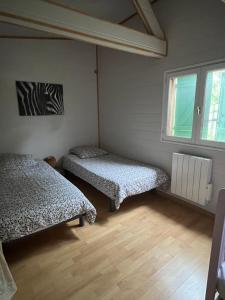 a room with two beds and a window at chalet atypique, Ile chambod in Echallon