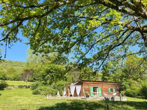 a small house in a field with a tree at chalet atypique, Ile chambod in Echallon +4 photos