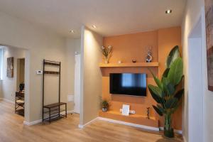 a living room with a flat screen tv on a wall at Casa Mateo - Mediterranean Studio in Bielefeld