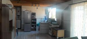 a small kitchen with a refrigerator and a window at casita de campo in Chillán
