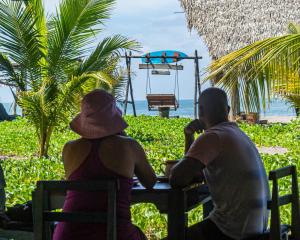 two people sitting at a table looking at the ocean at Entremares in Boca del cielo