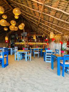 a restaurant with blue tables and chairs and chandeliers at Entremares in Boca del cielo