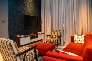 a living room with orange furniture and a television at The Maridoc in Lagos