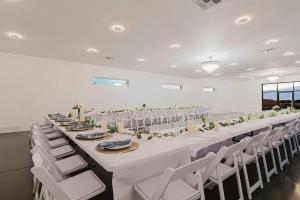 a long table in a room with white chairs at Sunset Acres Ideal for all Occasions in Clermont