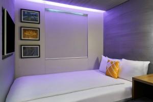 a bedroom with a white bed with a window at Four Points Flex by Sheraton Birmingham Jewellery Quarter in Birmingham