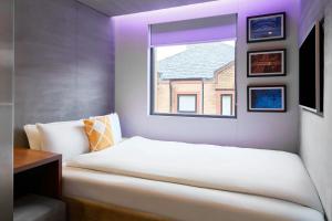 a bedroom with a white bed and a window at Four Points Flex by Sheraton Birmingham Jewellery Quarter in Birmingham