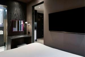 a bedroom with a flat screen tv and a bed at Four Points Flex by Sheraton Birmingham Jewellery Quarter in Birmingham