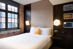 a bedroom with a large bed and two windows at Four Points Flex by Sheraton Birmingham Jewellery Quarter in Birmingham