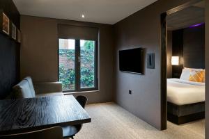 a hotel room with a bed and a table and a window at Four Points Flex by Sheraton Birmingham Jewellery Quarter in Birmingham +6 photos