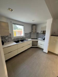 a large kitchen with white cabinets and a window at Villa Panama con piscina - Mazara del vallo in Mazara del Vallo