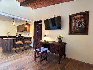 a living room with a desk with a television on the wall at Hacienda Casa Grande, suite esmeralda in Guadalajara +14 photos