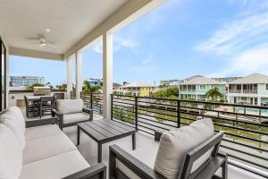a balcony with chairs and tables and a view of the ocean at Oyster Cluster in Fort Myers Beach