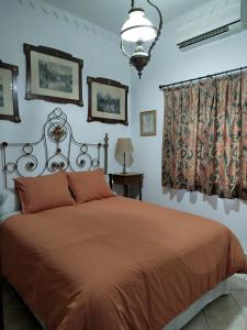 a bedroom with a bed with a orange bedspread at Casa Rural del Guadalora in Hornachuelos