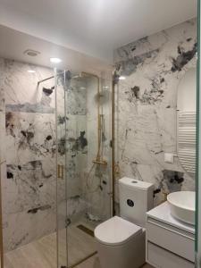 a bathroom with a shower and a toilet and a sink at Hotel Buganvília in Funchal
