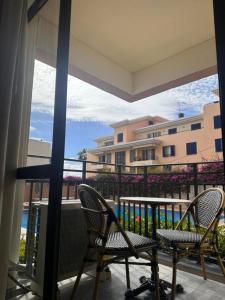 a balcony with chairs and a view of a building at Hotel Buganvília in Funchal