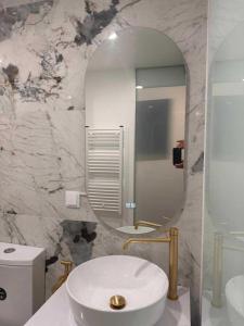 a bathroom with a white sink and a mirror at Hotel Buganvília in Funchal
