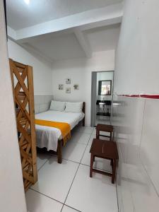 a small bedroom with a bed and a wooden ladder at Nova Conquista in Paraty