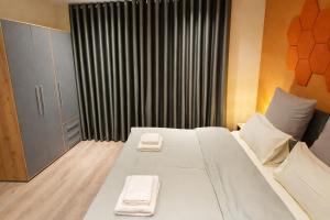 a bedroom with a large white bed with towels on it at Casa Mateo - Mediterranean Studio in Bielefeld