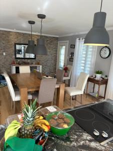Eine Küche und ein Wohnzimmer mit einem Tisch und einer Obstschale. in der Unterkunft Chalet St-Côme in Saint Come