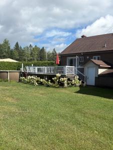 ein Haus mit Terrasse und Garten in der Unterkunft Chalet St-Côme in Saint Come