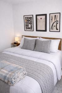 a white bedroom with two beds with pillows at Studio 929 Gold Star 400m Ferry to Rio 1Gb Wi-Fi in Niterói