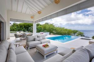 a living room with a couch and a swimming pool at Villa Flores Corales 84 - Coral Estate in Willibrordus