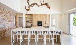 a kitchen with a large white island with bar stools at Villa Flores Corales 84 - Coral Estate in Willibrordus