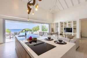 a kitchen and living room with a view of the ocean at Villa Flores Corales 84 - Coral Estate in Willibrordus