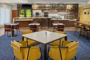 a dining room with tables and yellow chairs at Courtyard Birmingham Hoover in Hoover