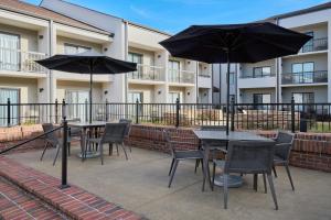 a patio with tables and chairs and umbrellas at Courtyard Birmingham Hoover in Hoover