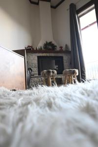 a living room with a fireplace and two animal statues at Valley Parnass in Arachova +5 photos