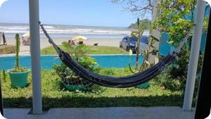 a hammock in a yard next to a beach at Casa de temporada enfrente a praia in Itanhaém