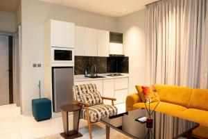 a living room with a yellow couch and a kitchen at The Maridoc in Lagos