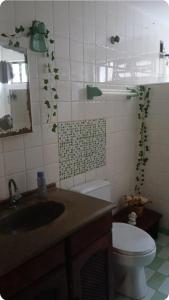a bathroom with a sink and a toilet at Casa de temporada enfrente a praia in Itanhaém +24 photos