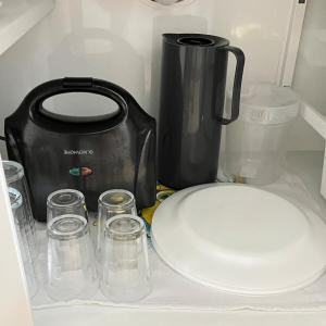 a toaster and a plate and glasses in a refrigerator at Studio Palm Garden em Nova Andradina in Nova Andradina