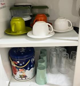 a shelf full of dishes and cups in a refrigerator at Studio Palm Garden em Nova Andradina in Nova Andradina