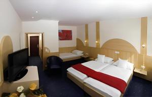 a hotel room with a bed and a flat screen tv at Hotel Hecher in Wolfsberg +34 photos
