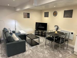 a living room with a couch and a table and a television at Studio 1 in Howden