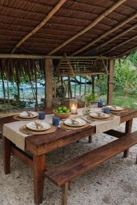 a wooden table with plates of food and a candle at Beachfront on Aore Island Private Island Stay in Aimbuei Bay