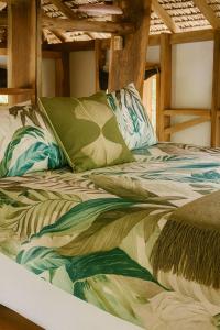 a bed with a colorful comforter and pillows on it at Beachfront on Aore Island Private Island Stay in Aimbuei Bay +24 photos