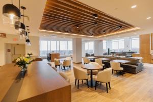 a lobby with tables and chairs in a building at Highpoint Hotel in Sioux Falls