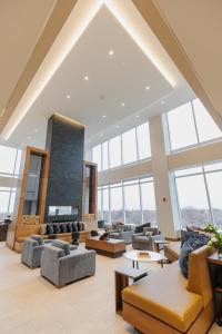 a large lobby with couches and tables and windows at Highpoint Hotel in Sioux Falls