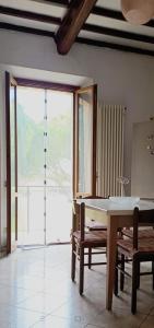 a room with a table and chairs and a large window at Maria Luisa Home in Poggibonsi +1 photo