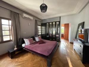 a bedroom with a bed and a television in it at Villa Chayol - Beautiful, spacious, bright! in Cotonou