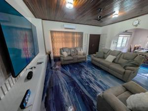 a living room with couches and a flat screen tv at Bendo house in Accra