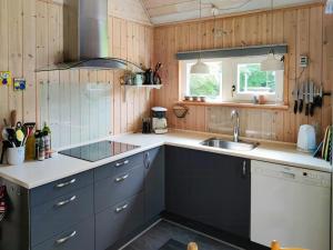 a kitchen with blue cabinets and a sink and a window at Home Near Beach With Wilderness Bath in Sindrup