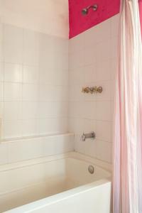 a bathroom with a tub and a pink shower curtain at HOTEL & RESTAURANTE Los solaches in Zitácuaro